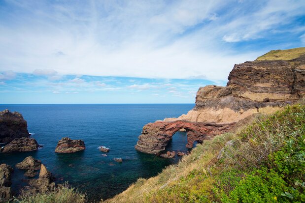 Le littoral de Kuniga, sur la partie ouest de Dôzen, rengorge de magnifiques falaise escarpées et de formations rocheuses comme, par exemple, le Tsûtenkyô (le pont vers les ciel), qu’on voit au centre de la photo. (Pixta)