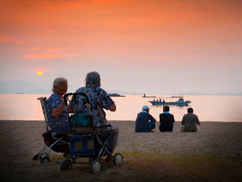 島のお盆。夕日と共に祖先を送るために浜に集まる島人たち（白石島）