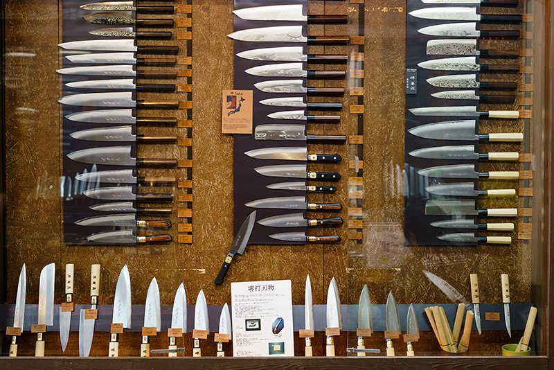 Ножи разных форм и размеров на витрине магазина Tower Knives Osaka. К ним прилагается и объяснение на английском языке