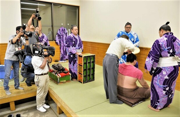 Yokozuna Hakuhō, after losing a match to Gōeidō on the twelfth day of the May 2015 tournament. Hakuhō sits with his back to reporters, unwilling to be interviewed. (© Kyōdō)