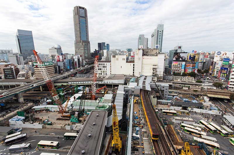 涩谷站东口，东横线的地上旧站台和百货公司建筑拆除后，正在进行重建工程（摄于2016年10月）。银座线涩谷站的站台将在2019年前移至黄色电车驶过的位置