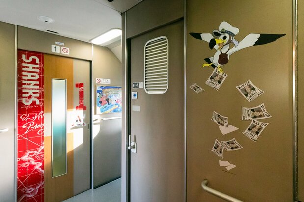 Wanted posters issued by the Navy are scattered throughout the train. (© Kusano Seiichirō)