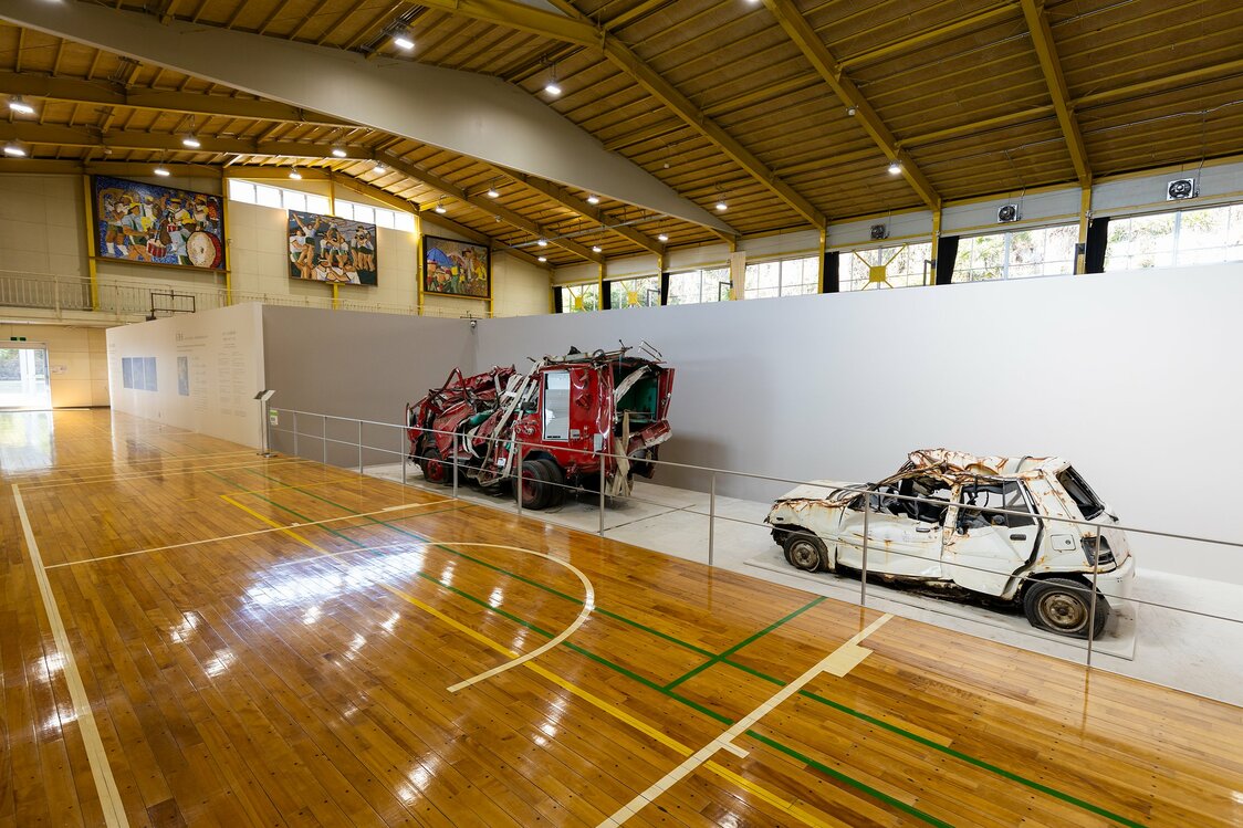 体育館には初代「がんばろう！石巻」看板と共に、被災車両や応急仮設住宅などが保存してある