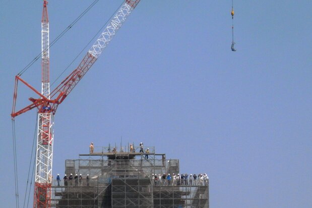 A crane maneuvers the shachihoko sculptures into place atop the main donjon of Kumamoto Castle in April 2018. (Photo courtesy of Kumamoto City)