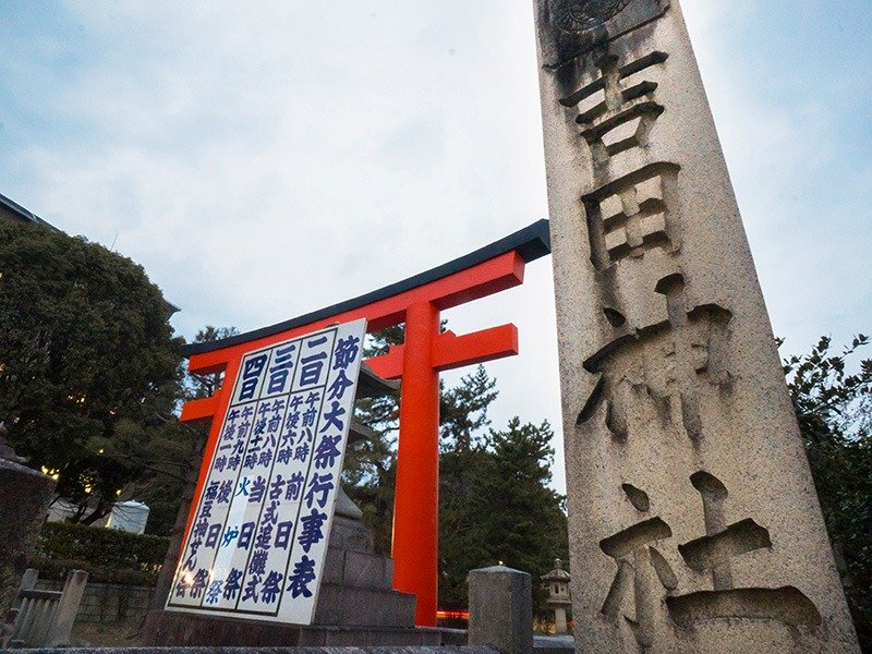 Programme des manifestations du grand festival du sestubun, affiché devant le portique ichi-no-torii du sanctuaire Yoshida.