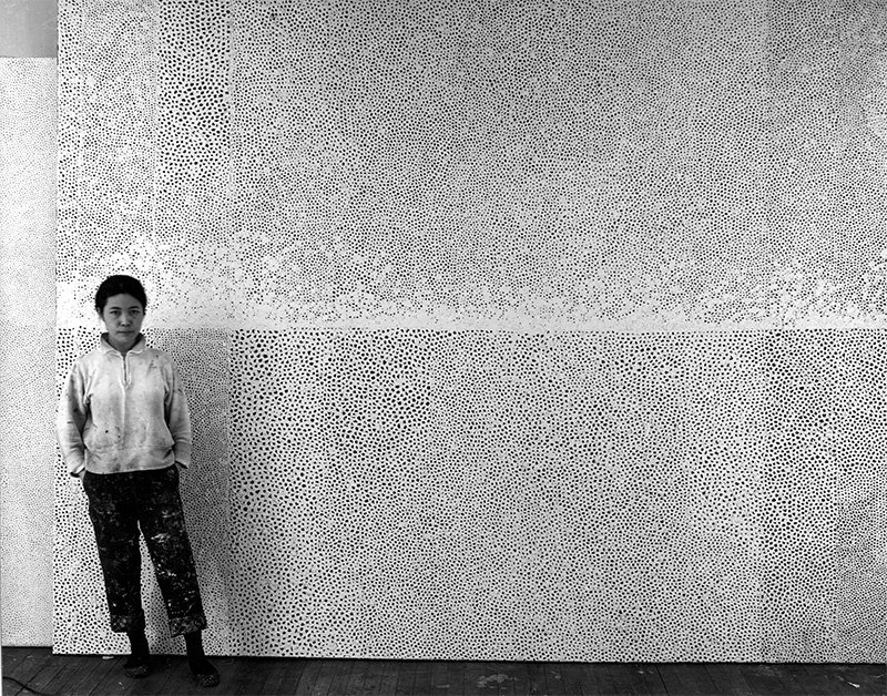 巨大なネット・ペインティングの前にて（1961） ©YAYOI KUSAMA