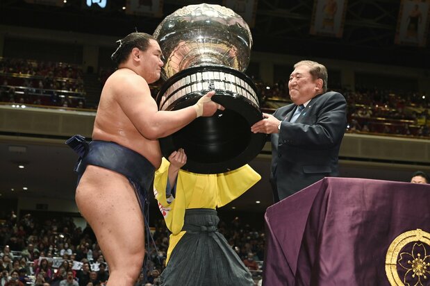 Ishiba Shigeru presents the Prime Minister’s Cup to tournament champion Hōshōryū in January 2025. (© Jiji)