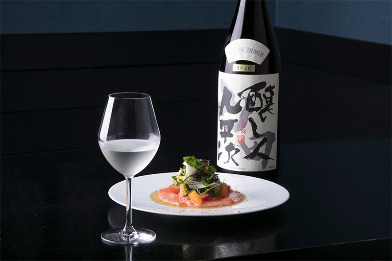 “酿人九平次”纯米大吟酿2016山田锦EAU DU DESIR（希望之水）。最佳搭配为口感清香的冷盘菜，在橄榄油拌腌渍三文鱼上，配以凸顶柑、草莓、西红柿、各种嫩菜叶和香草类（协助：“MiwaMiya”东京阿佐之谷）