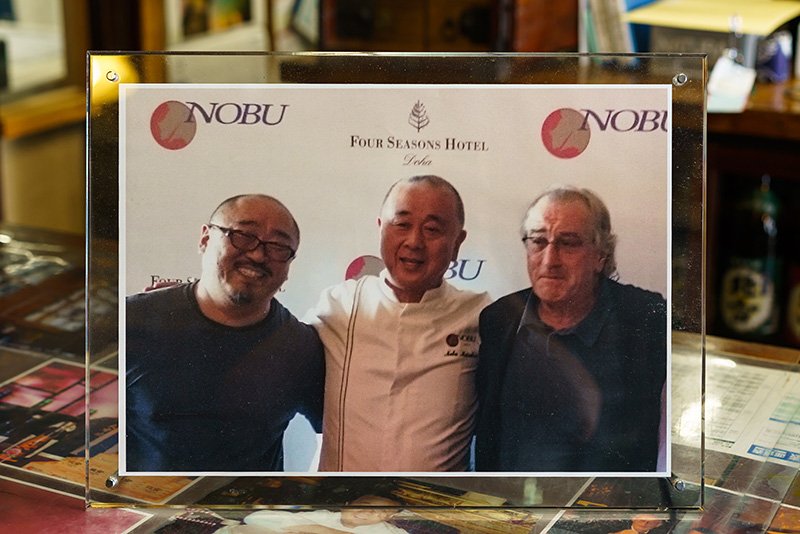 摆放在店内的照片。左起依次为羽豆社长、松久信幸、德尼罗