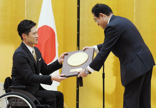 Kunieda Shingo, left, receives the People’s Honor Award from Prime Minister Kishida Fumio. (© Jiji)