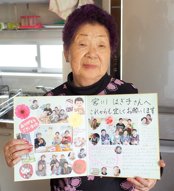 Mme Miyakawa tient une carte portant des messages que ses voisins lui ont écrits quand elle a quitté son logement provisoire. « Le chagrin causé par la perte de nos maisons ne nous quittera jamais, mais l'entraide nous a permis de reprendre courage et faire notre possible. »