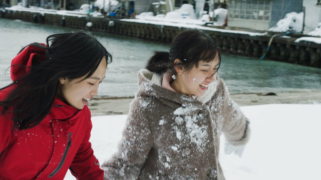 初めて触れる雪にはしゃぐアン（左）とニュー　©2020 E.x.N K.K. / ever rolling films