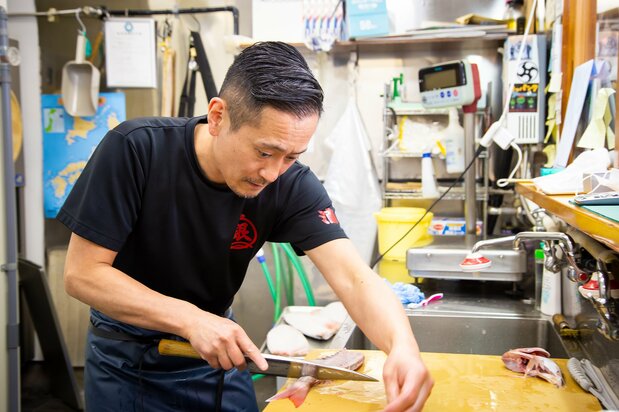 Morita fillets a red snapper. He is always willing to teach customers how to prepare fish.