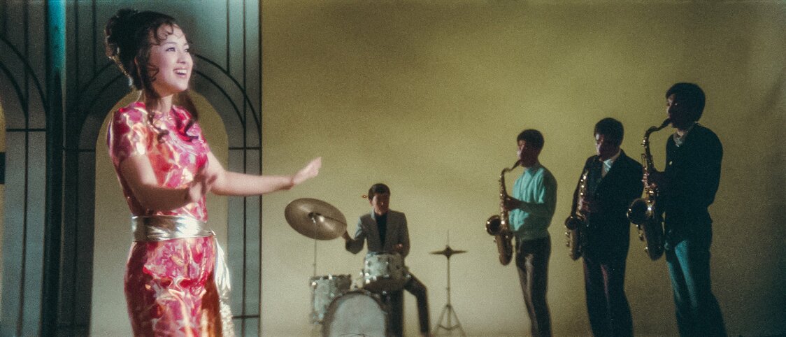 中国語で映画の主題歌を歌うジュディ・オング。万博のために書き下ろされたという楽曲の詞にも注目　© 2025 Taiwan Film and Audiovisual Institute. All rights reserved.