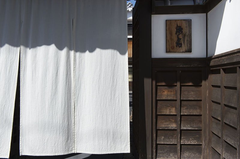 La cortina noren de color blanco confiere pulcritud. El cartel que pone ‘Genbei’ fue escrito por Nakaya Genbei, un líder local del período Edo.