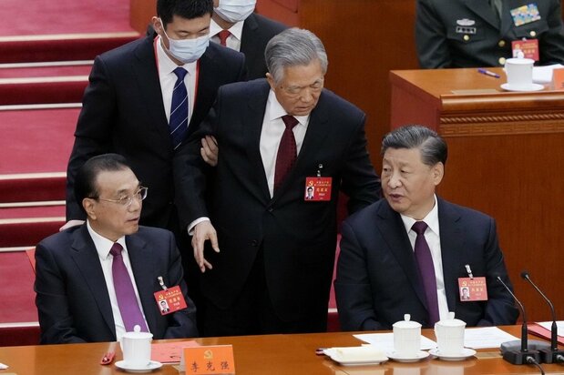 第20回中国共産党大会の閉幕式で、退席する胡錦濤前総書記に声をかけられる習近平総書記(右)。左は李克強首相=2022年10月22日、北京の人民大会堂(共同)