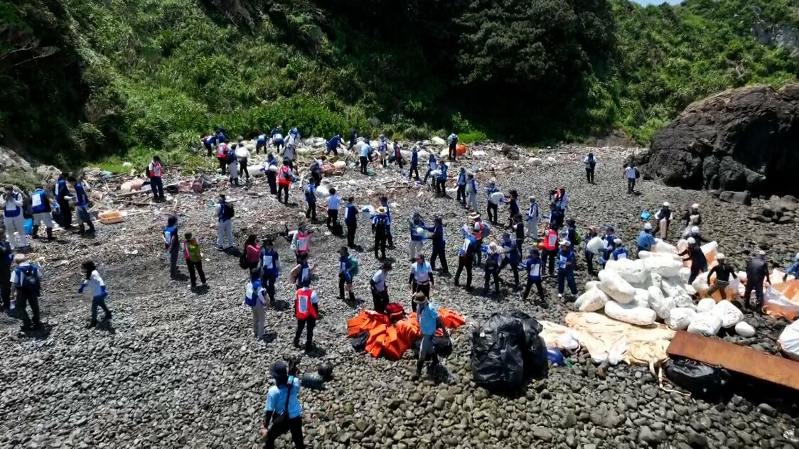 在布满石块，行走艰难的海岸，启动人海战术展开清扫（图片：日本财团）