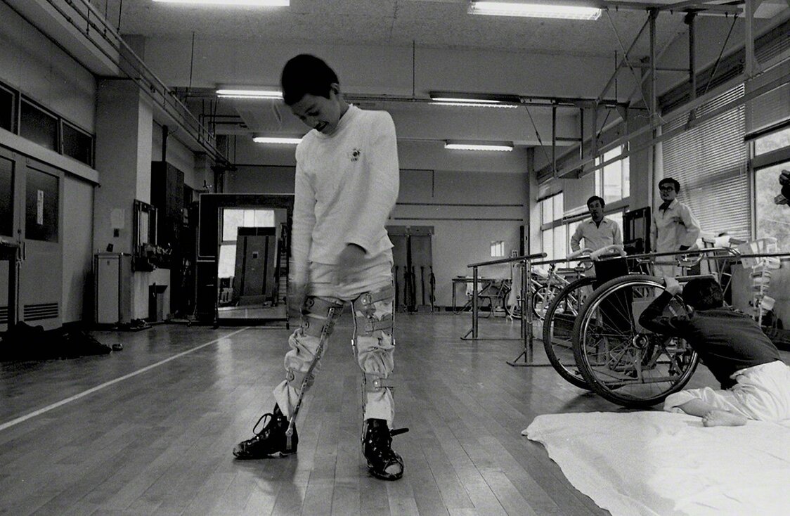 Nagai Isamu à l’âge de 14 ans. En partie paralysé depuis l’enfance, il a dû se soumettre à des séances quotidiennes de rééducation particulièrement éprouvantes. Mais les traitements se sont tous avérés sans effet. Passionné de photographie depuis son plus jeune âge, il a bénéficié des encouragements de William Eugen Smith qui lui a donné accès à son laboratoire pour qu’il puisse y développer ses propres photos. (Photo prise en 1973)