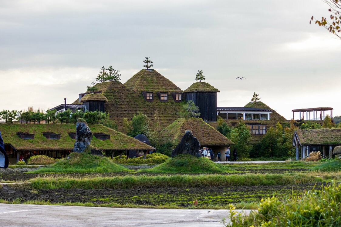 Grass-clad buildings blend into the natural landscape. (© Nippon.com)
