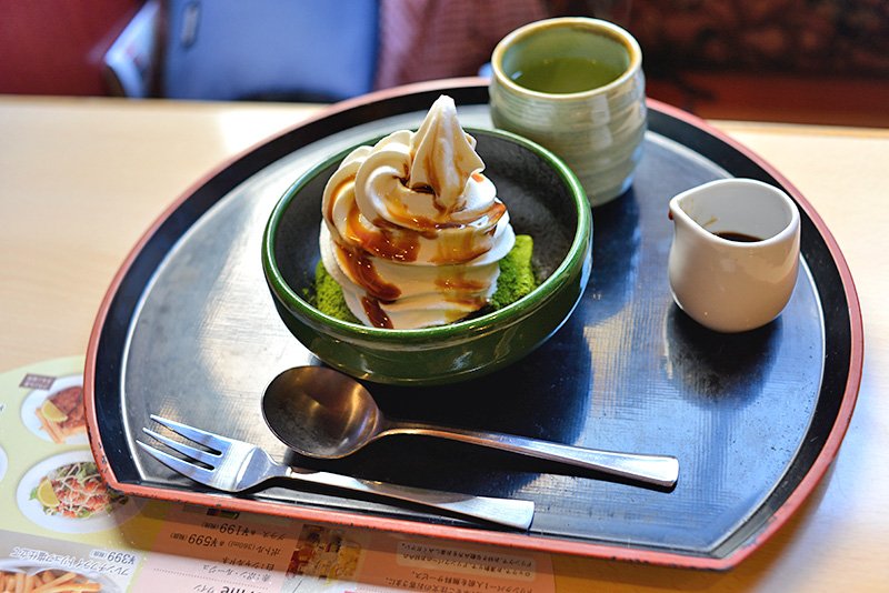 Warabimochi (dulce de almidón de helecho) con té verde espolvoreado, helado, nata y azúcar mascabado.