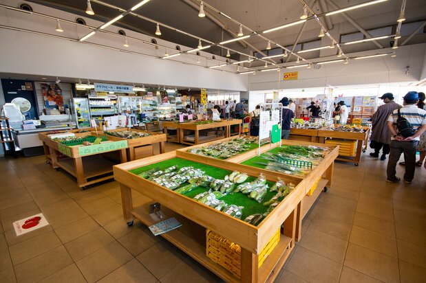 朝採れの野菜が平台に並ぶ2階のやさい館。果物の生ジュースや地ビールが飲めるコーナーも