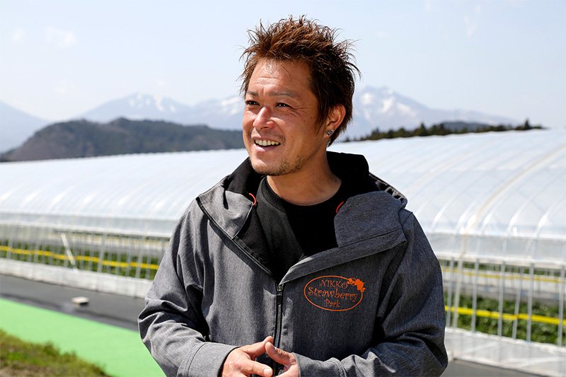 「日光ストロベリーパーク」の沼尾浩明さん。イチゴの温室からは男体山と女峰山が大きく望める。