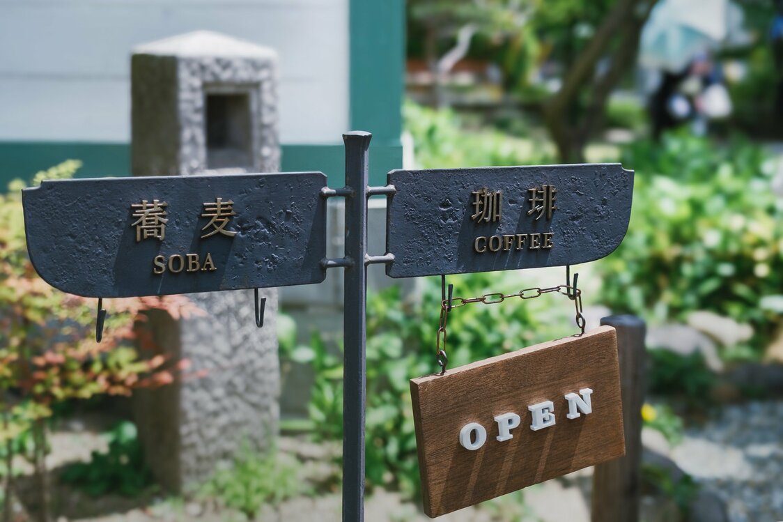 入口處「咖啡」指示牌下掛著「OPEN」的牌子，可知咖啡館正在營業