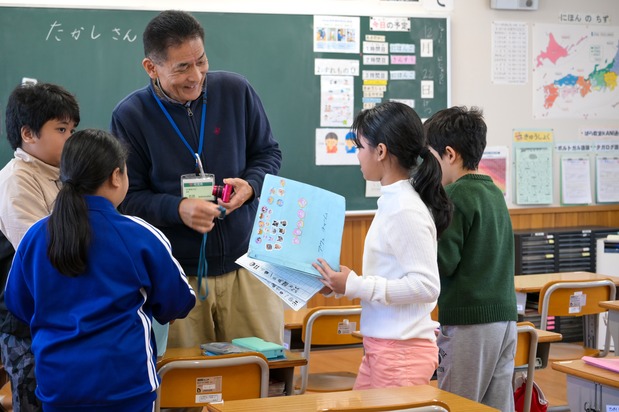 Wakahara, director de Bara Kyōshitsu (en el centro), interactúa con un grupo de menores. “Queremos que los niños se sientan a gusto viniendo aquí, por lo que nos esforzamos por elogiarlos incluso por los más mínimos avances”, afirma. (© Kumazaki Takashi)