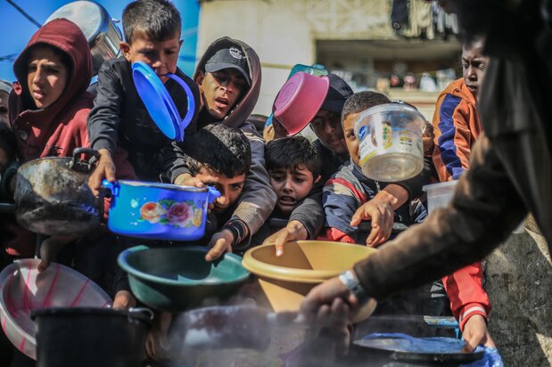 慈善団体から食事を受け取るパレスチナの子どもたち(dpa via Reuters Connect)