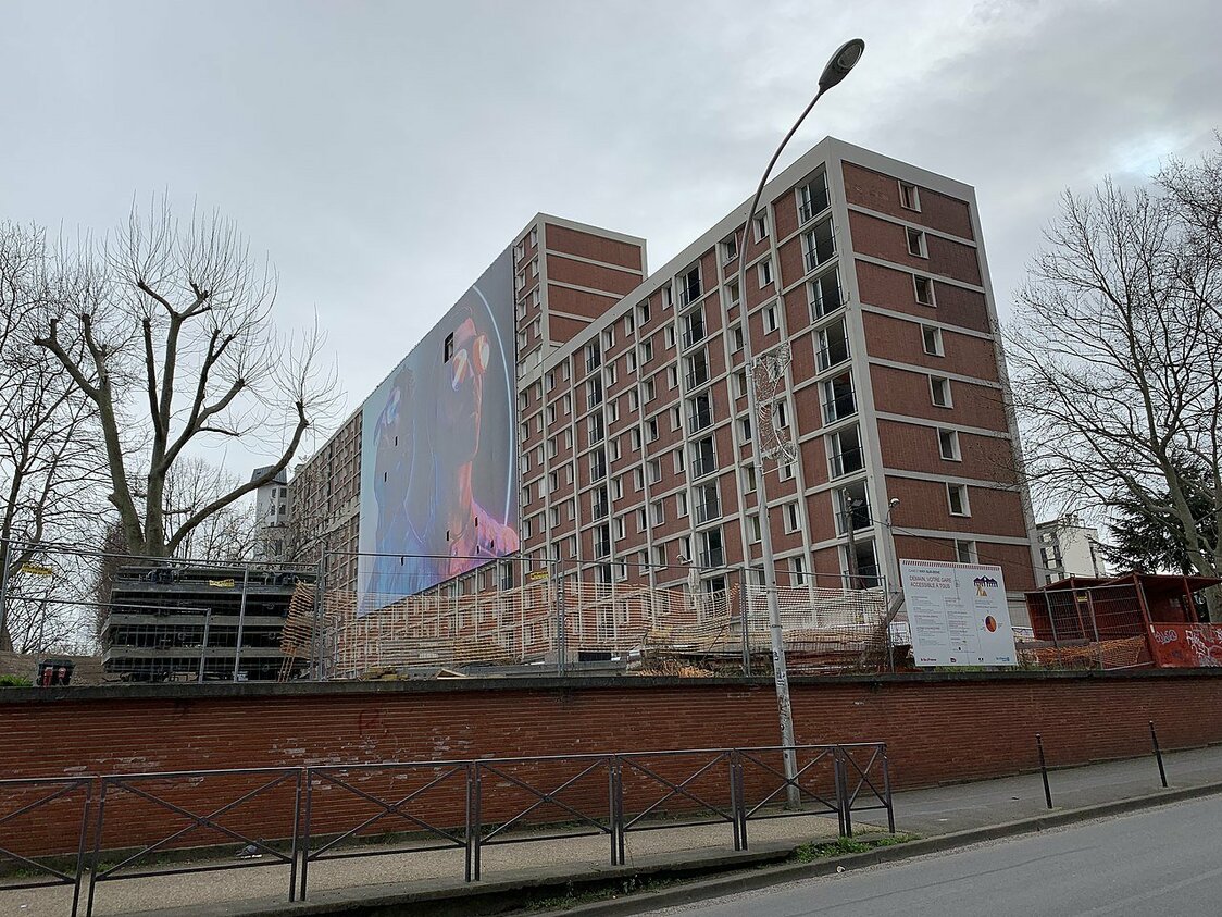 解体工事が始まったガガーリン団地。壁にはここで育ったラップ・デュオ「PNL」のアルバムの巨大な広告パネルが掲示された（2020年2月、フランス、イヴリー・シュル・セーヌ市）　cc : Chabe01