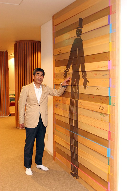 À la Rainbow House de Sendai, les visiteurs peuvent inscrire leur taille sur le mur à côté d’un illustration représentant Ashinaga Ojisan (Tonton longues jambes).