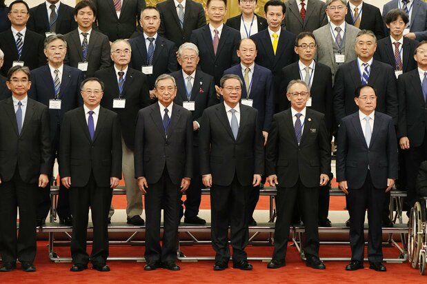 中国の李強首相(前列右から3人目)と記念写真に納まる日本国際貿易促進協会の代表団メンバーら=2023年7月5日、中国・北京の人民大会堂(時事)