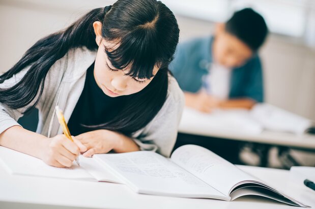都市圏では中学受験のための塾で夜遅くまで勉強する子もいる（PIXTA）