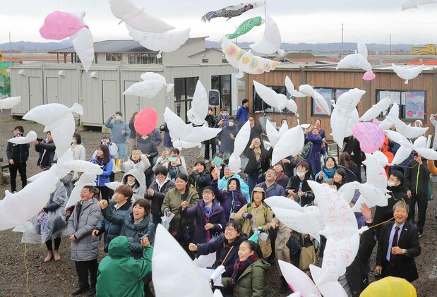 東日本大震災で多くの犠牲者が出た宮城県名取市の閖上地区で、メッセージを書いたハト型の風船を飛ばす追悼行事が行われた。同地区出身の南部陽向さん(15)は、震災で亡くなった幼稚園の先生に「震災から立ち直ることができたよ。私のことを見守って欲しい」と伝えたくて風船を空に放った=2019年3月11日(時事)