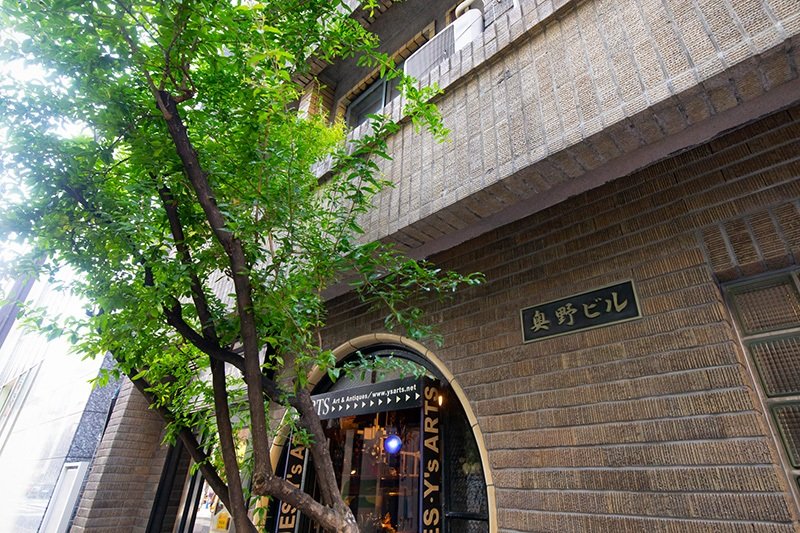 La señal cerca de la entrada del edificio y la ventana redonda de una tienda de antigüedades.