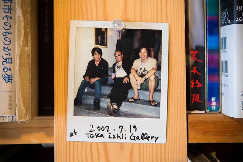 写真集食堂めぐたまの書棚の片隅にあった記念写真。左から森山大道さん、荒木経惟さん、飯沢耕太郎さん（撮影＝ニッポンドットコム編集部）