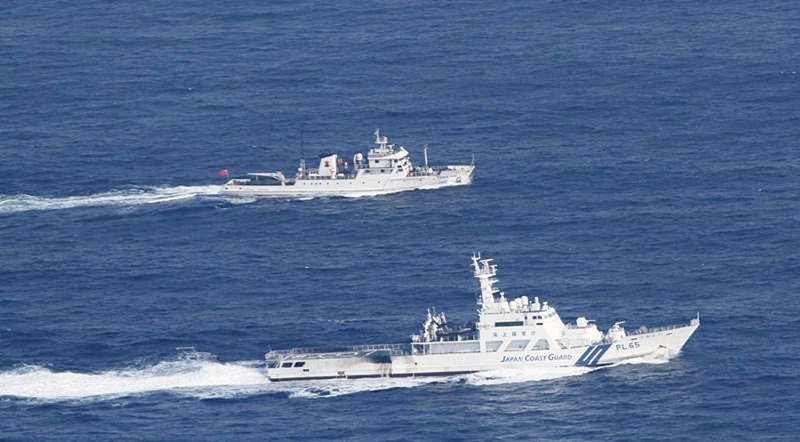 在尖閣諸島海域的領海警備行動中，與中國漁業監督船「漁政35001」（遠處）對峙的海上保安廳巡邏船（近前）提供：海上保安廳©時事通信社