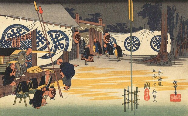 « Les Cinquante-trois étapes du Tôkaidô : une Matinée à Seki » (Tôkaidô go-jû-san tsugi Seki Honjin Hayatate), estampe de Hiroshige. Un palanquin attend. Au fronton du bâtiment de gauche, on voit accrochés sous la tenture, des écriteaux (sekifuda) qui devraient être au nom des envoyés du clan, mais en y regardant de plus près on y découvre une réclame pour des produits cosmétiques. Les armoiries sur la tenture ne correspondent d’ailleurs à aucun clan. Hiroshige, fidèle à son humour légendaire, s’est amusé à y styliser « Tanaka », les idéogrammes de son propre nom de famille. (Collections de la Bibliothèque nationale de la Diète)