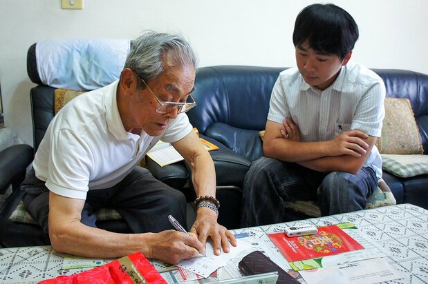 元台湾人日本兵を取材する陳柏棕さん(右)