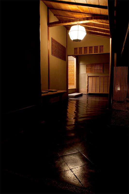 Al final de la leve oscuridad se vislumbra un farol encendido. Esta es la vista que nos lleva al vestíbulo (cortesía de Kōdaiji Wakuden).