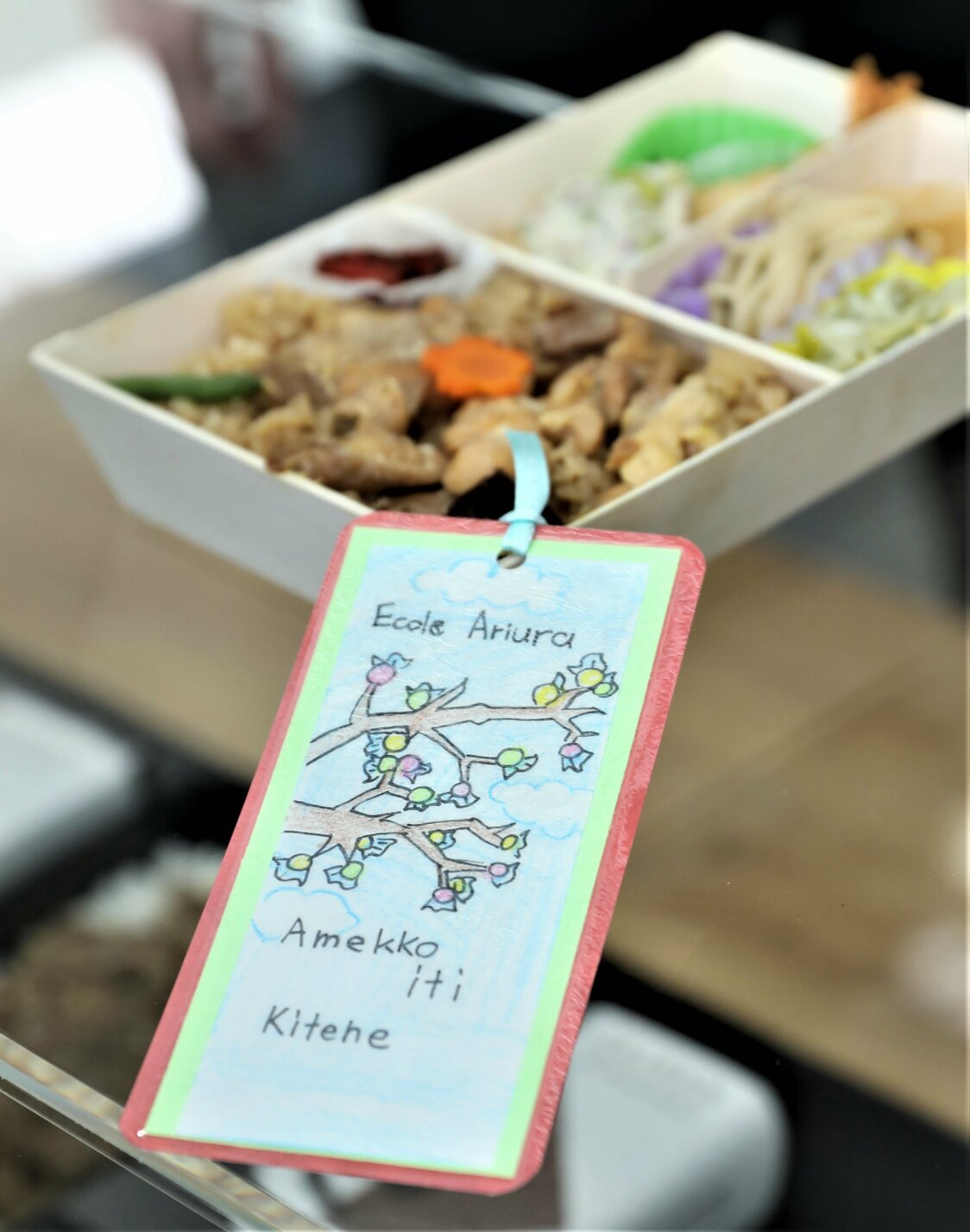 「秋田弁当」の購入者には、大館市内の小学生らがつくったしおりをプレゼント。「鶏めし」に合うお茶を中学生たちが開発、「おしながき」は高校生たちが制作。国際教養大（秋田市）の学生たちがフランス語のネーミングと店内で流す映像を企画するなど、たくさんの秋田県人の思いが込められている。　写真提供：花善