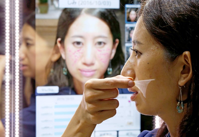 The makeup sheet exhibited by Panasonic. Sensors embedded in the mirror stand are used to analyze an individual’s skin condition, and a specialized printer prints a sheet that corrects for spots and pores. (Photo © Reuters/Aflo)