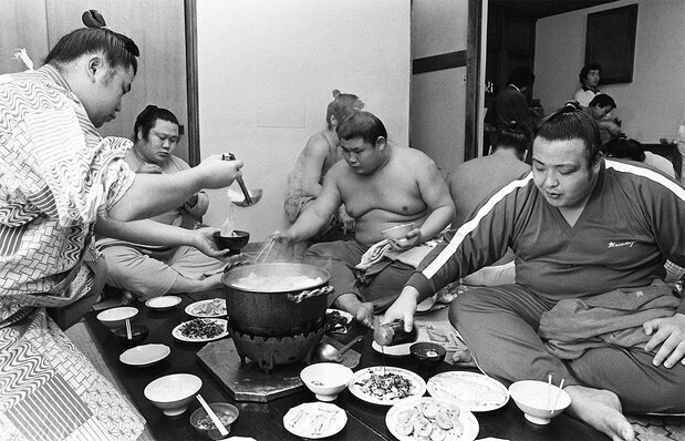 春日野部屋でちゃんこを囲む力士たち。“若い衆”は関取や親方たちの給仕を終えた後に食事をする 時事