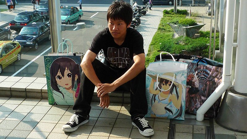 “Con esto, se terminó el verano”, parece decir la expresión de este joven llegado al Comiket con el primer tren de la mañana y que ahora se dispone a regresar con sus adquisiciones tras un largo día de disfrute.