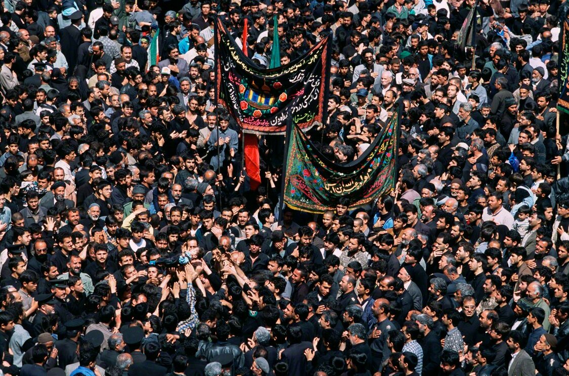 Hommes portant la dépouille et pleurant un enfant considéré comme le dernier fils de l’imam Hussein, tué d’une flèche dans la région de Karbalah, Irak. Photo prise à Mashhad, Iran, en 2001. (Extrait de Persia)