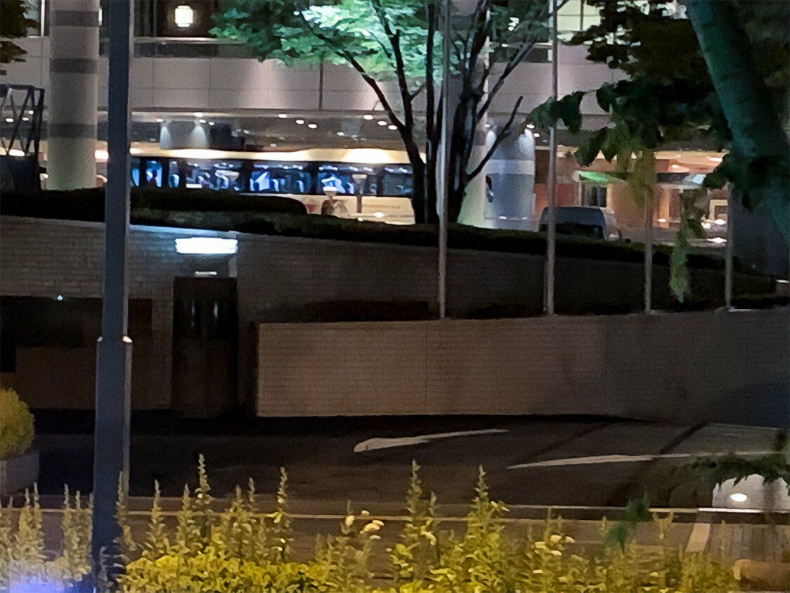 支援者の自動車が待機する中、脱出できなかったピエリアンアウンさんを乗せた空港行きのバス（奥）がミャンマー代表チームの宿舎から発車するところ（2021年6月、大阪）撮影：筆者
