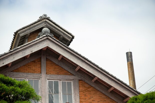 The roof peak on the silk-reeling plant is embellished with a decorative tile endpiece depicting the sun rising above waves.
