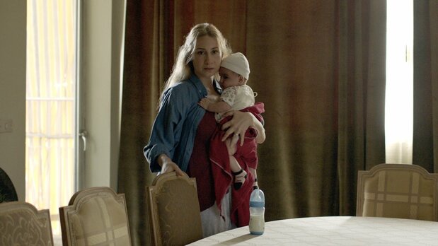 乳飲み子を抱えて階下に避難してきた若妻ハリマを演じるディアマンド・アブ・アブードはレバノンの実力派女優 © Altitude100 – Liaison Cinématographique – Minds Meet – Né à Beyrouth Films