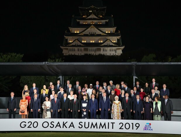 大阪城を背に、集合写真に納まるG20各国首脳と配偶者ら＝2019年6月28日、大阪市中央区（時事）