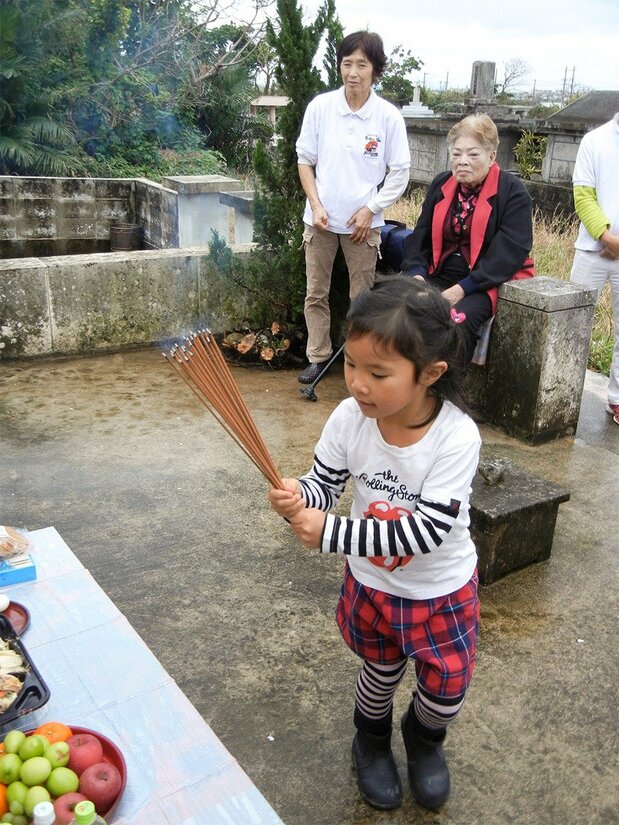 台湾系の人たちが十六日祭で線香を供える。台湾から取り寄せた細長い線香である、2016年2月23日、沖縄県石垣市(筆者撮影)